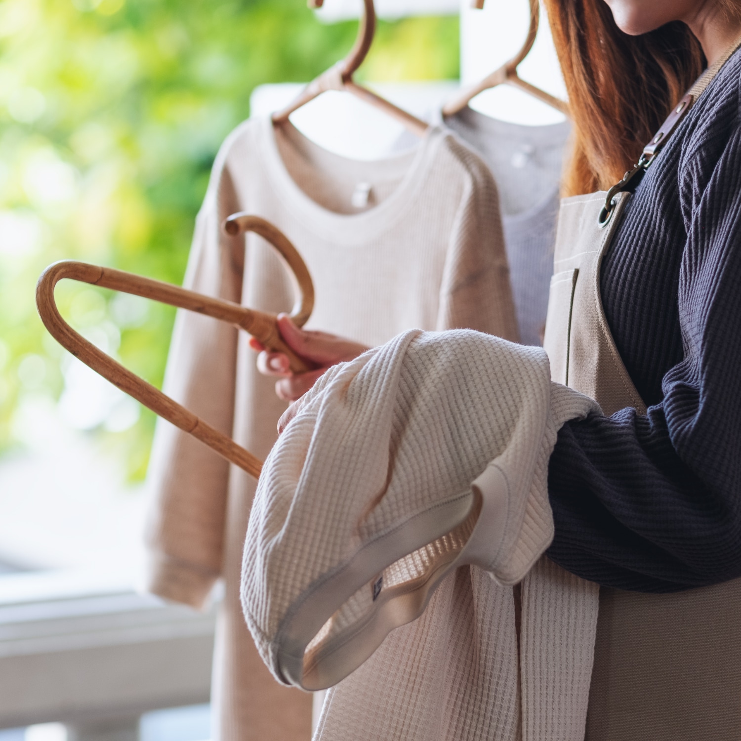 A housewife doing laundry, washing and hanging shirts on clothes